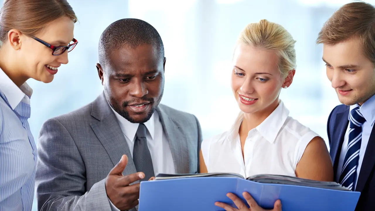 The leadership of an organization poring over a blue policy file.
