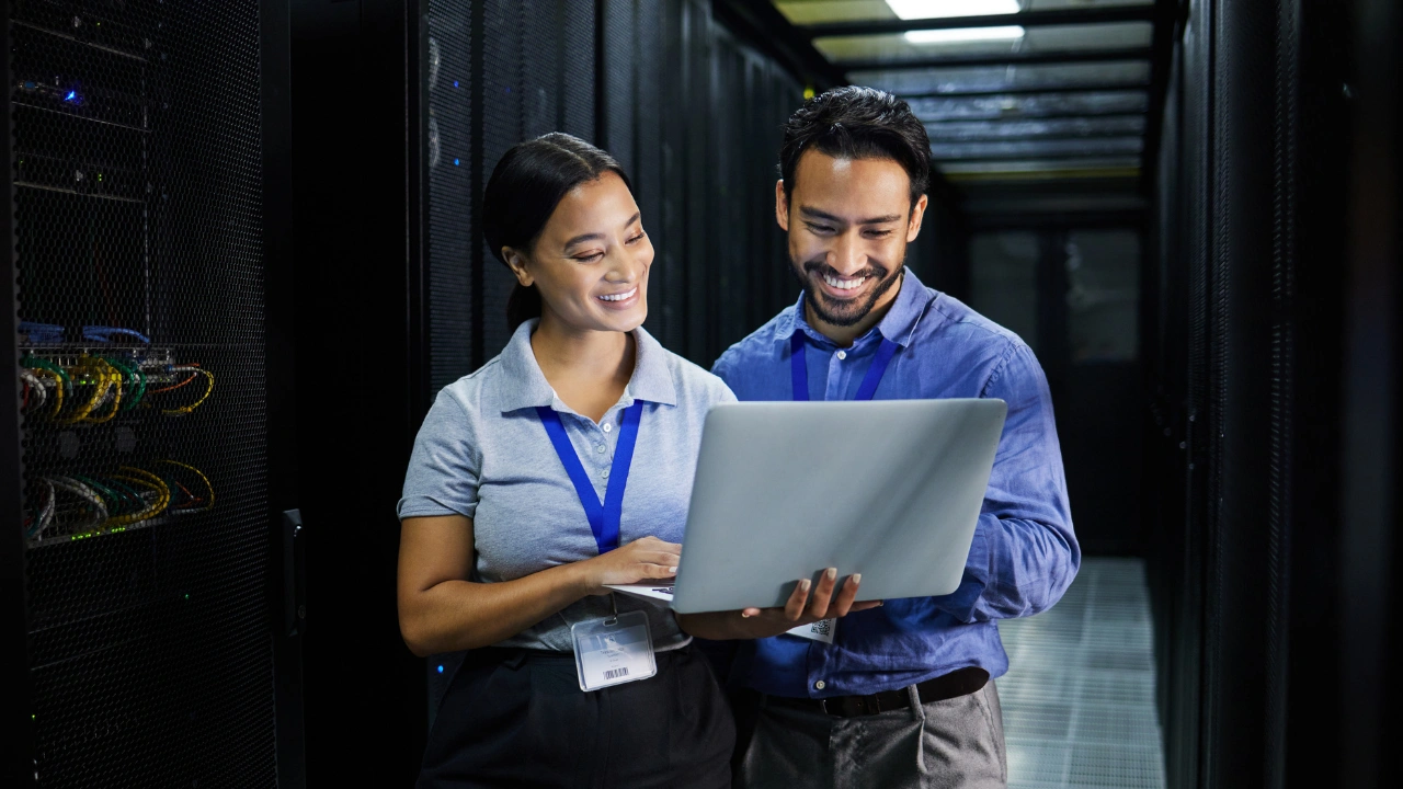 Two IT professionals looking at a laptop screen