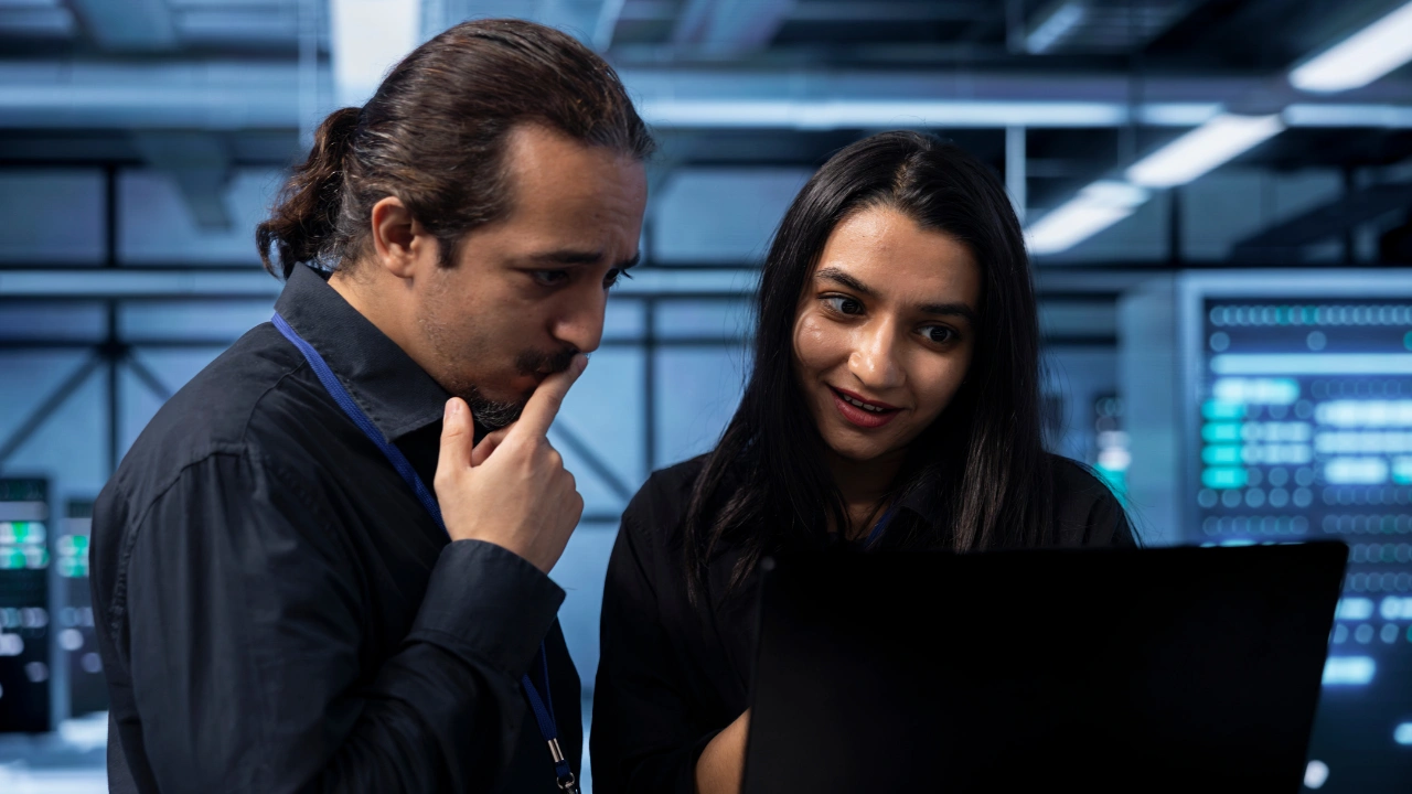 A male and a female department head looking at a laptop